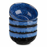 Starry reactive glaze cereal bowls in blue on a rustic wooden table - filled with creamy soup - pasta - and fresh fruit salad for a cozy - celestial dining vibe