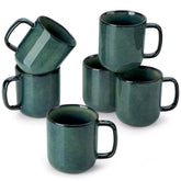 Starry gently curved green mugs set of 6 displayed on a wooden table with a coffee maker and a plate of pastries