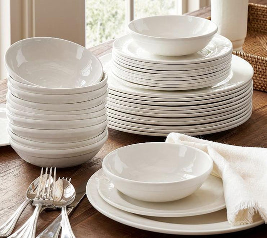 White dinnerware set with stacked plates and bowls on dining table showing practical everyday tableware option.