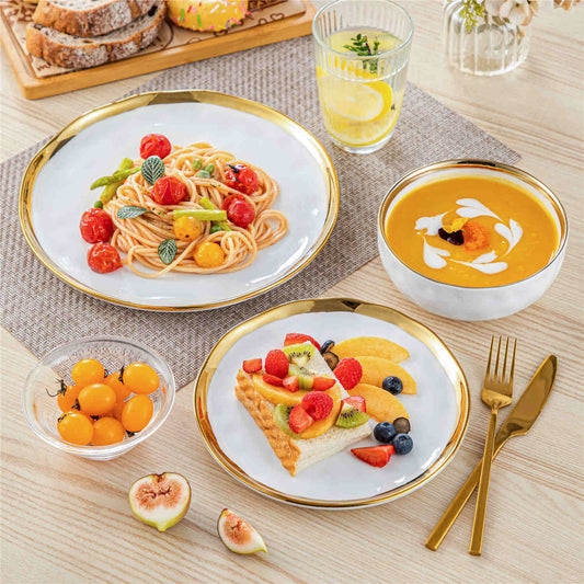 Lovecasa porcelain dinnerware with gold rim in white, served with pasta, fruit, and pumpkin porridge in close-up