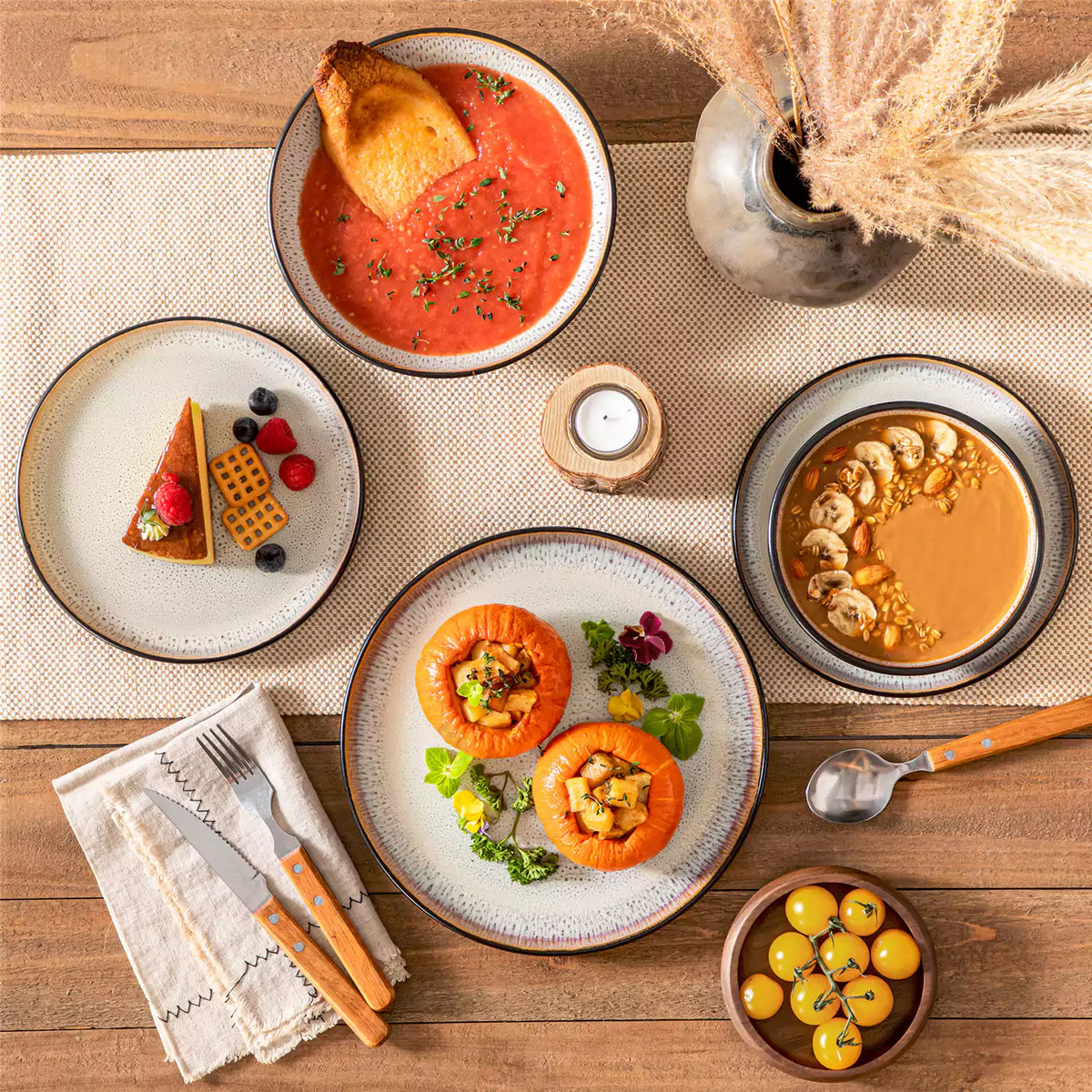 Amber stoneware 16 piece dinnerware set beige speckled glaze plates on a wooden table with linen table runner.