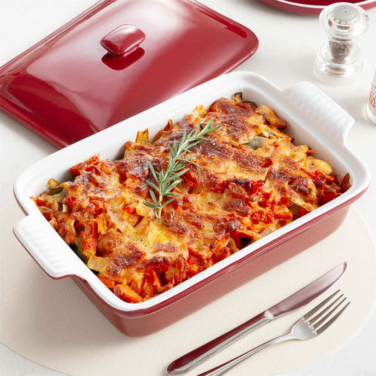 3.8Qt stoneware casserole with roasted food and bay leaf garnish on white table with pepper shaker.