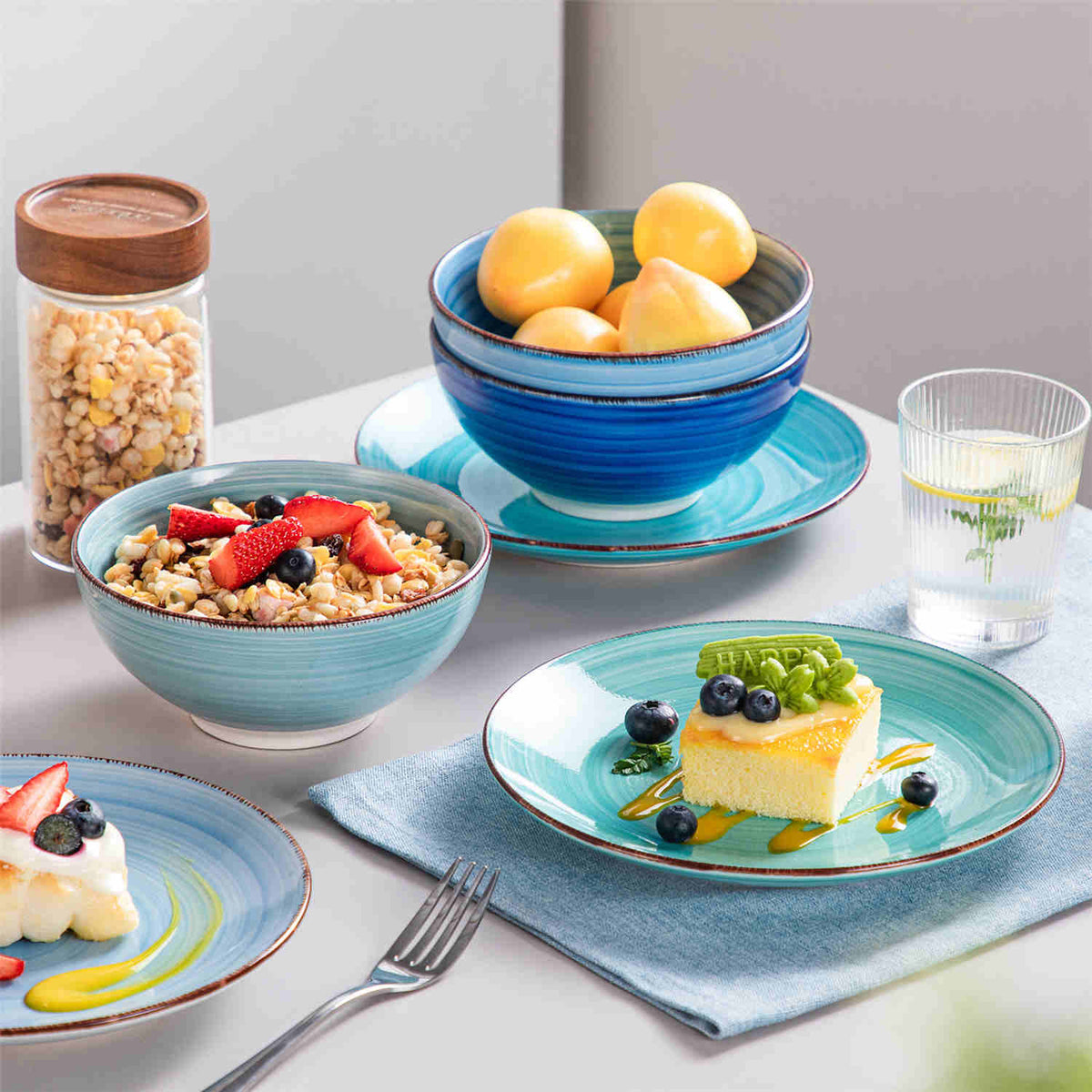 Bonita 24 piece blue stoneware set – dessert plates and tapered cereal bowls stacked with peach, oatmeal, and honey cake