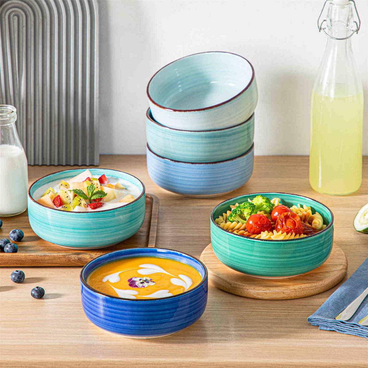 Bonita lipped edge stoneware bowls with oats and fruits on a woven mat, paired with lime water
