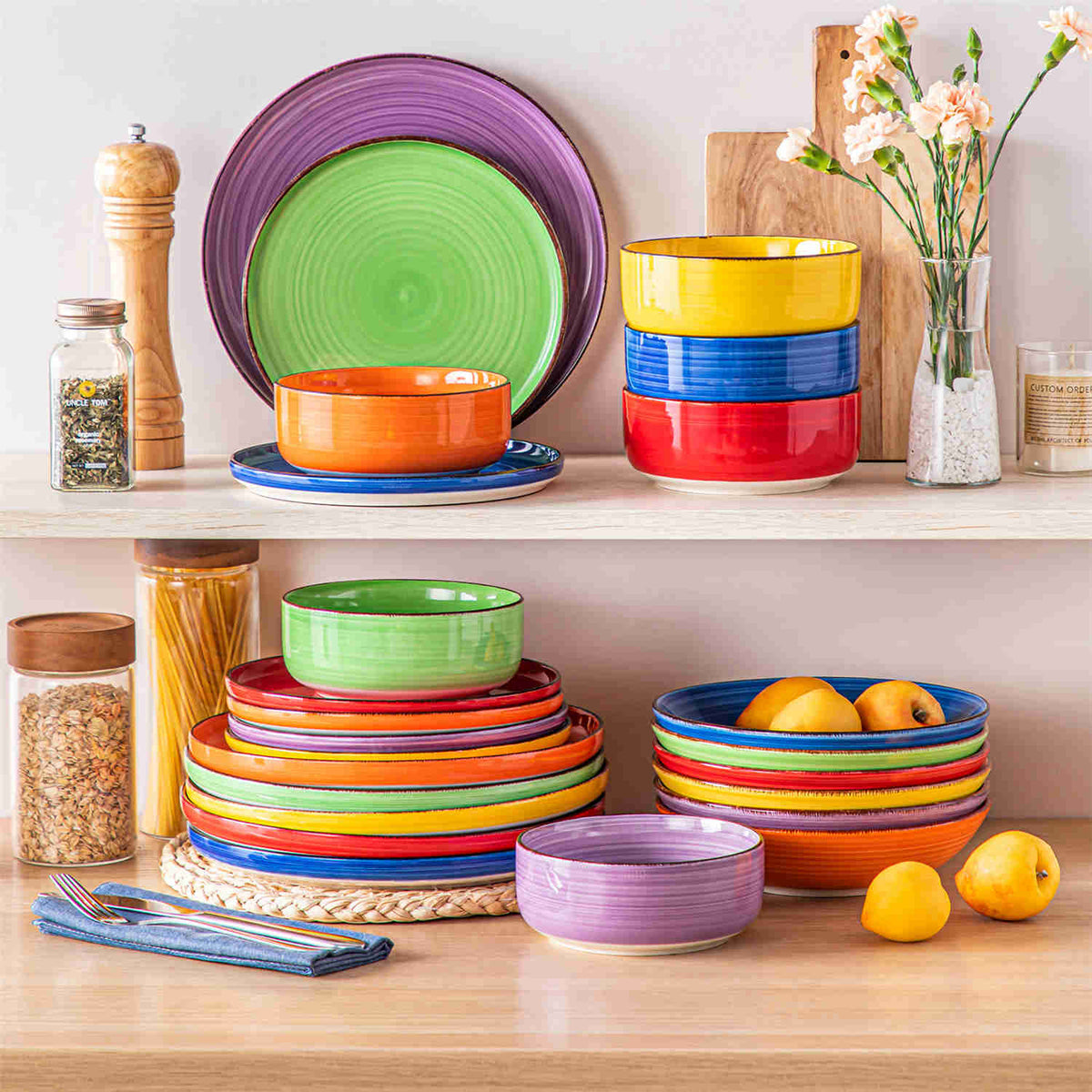 Stacked colorful Bonita stoneware dinnerware set for six with lipped edges, displayed in cabinet with floral decor