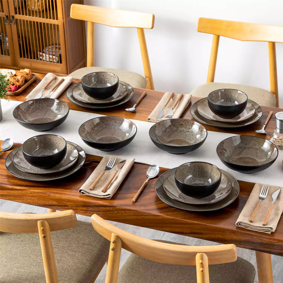 Bubble 16-piece stoneware dinnerware set with brown reactive-glaze plates and bowls on wooden table setting