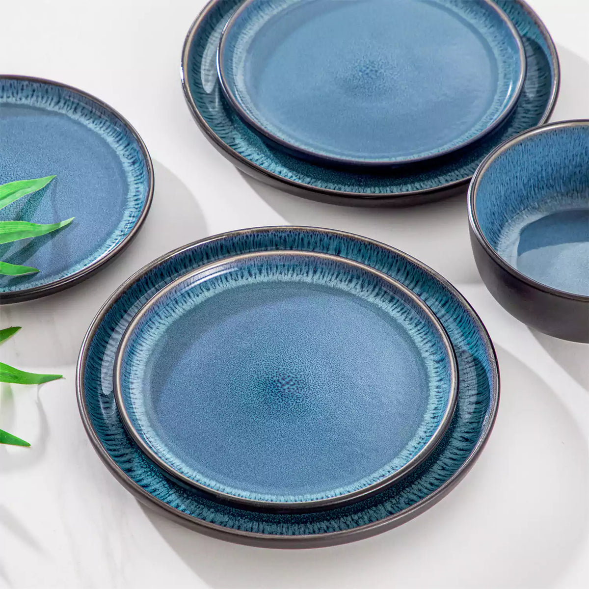 18-Piece Blue Stoneware Set With Lipped Edges And Reactive Glaze, Reflecting Mediterranean Culture And Modern Handcrafted Aesthetics.