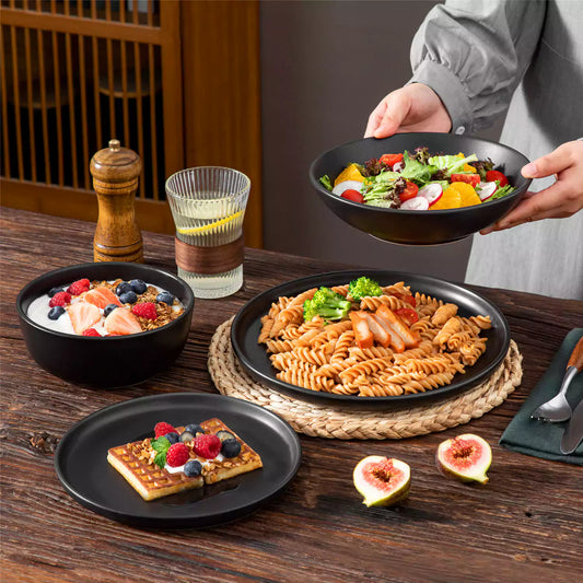 Playa 24-piece matte round dinnerware set featuring pasta, fruit salad, soufflé, figs, and lemon.