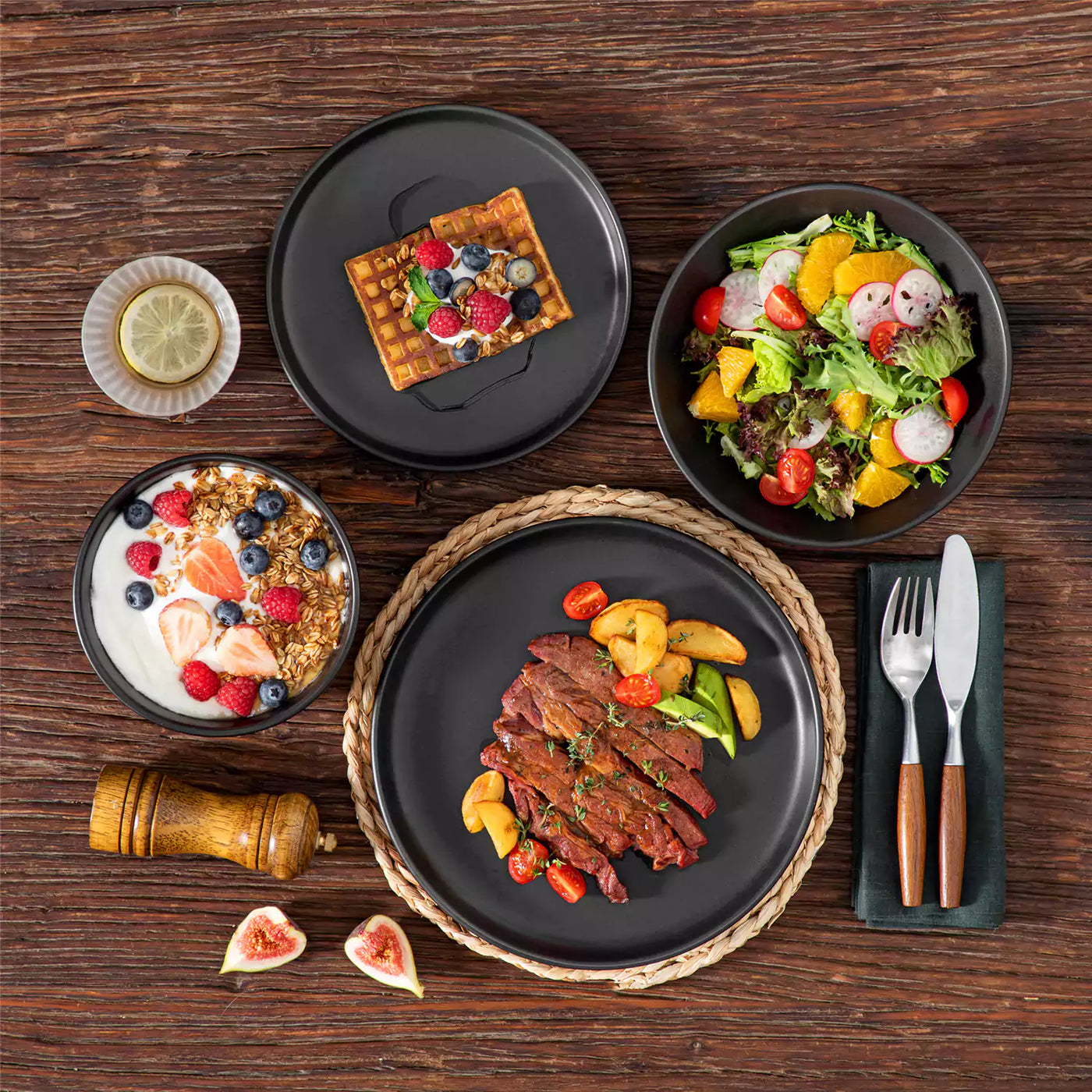 Black Playa 24-Piece Matte Stoneware Set on rustic wood table with vibrant dishes — sleek, modern dinnerware for stylish dining