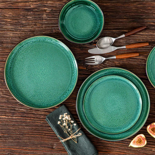 Playa 18-piece dinnerware set with green plates and bowls on wooden table with figs and dried flowers