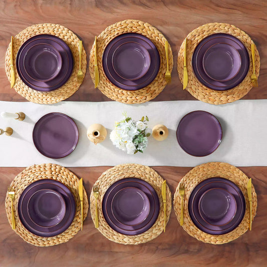Sata purple stoneware 24-piece lipped edge dinnerware set flat lay empty plates woven placemat white linen table runner candlestick ceramic vase decor.
