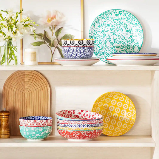 Selene vibrant porcelain pasta bowls set of 6 colorful ceramic dinnerware stacked in white wooden cabinet with fresh flowers and candles.
