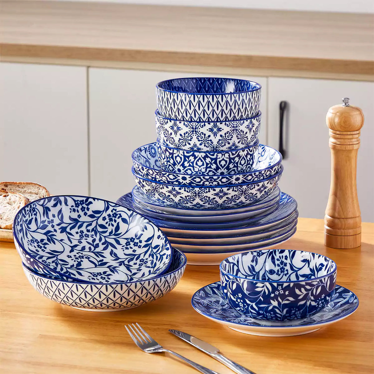 Modern Selene 16-piece stoneware dinnerware set neatly arranged on beige wooden dining table.