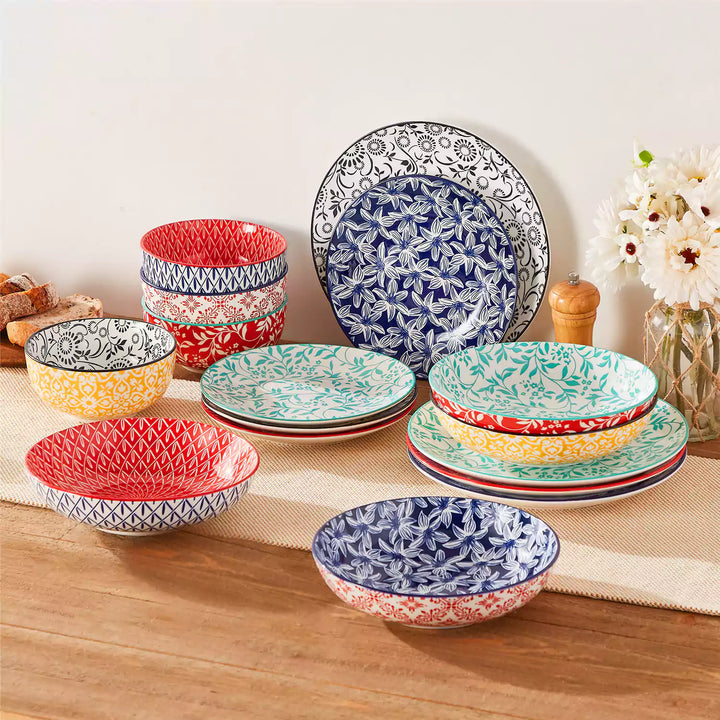 Selene porcelain 16 piece vibrant dinnerware set displayed on dining table showcasing indigo yellow and black floral geometric patterns.
