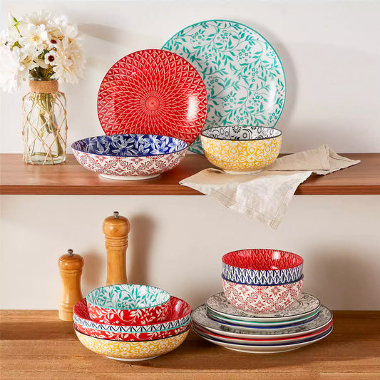 Selene 16-Piece vibrant dinnerware set arranged on wooden cabinet, space-saving display showing colorful patterns and modern tableware design.