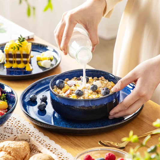 Starry reactive glaze stoneware dinnerware with blue oatmeal bowl filled with yogurt – lipped plates and bowls set for six