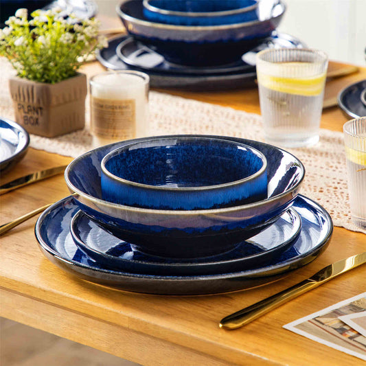 Starry blue stoneware plates and bowls stacked wooden table lace runner solo dining space saving storage reactive glaze.