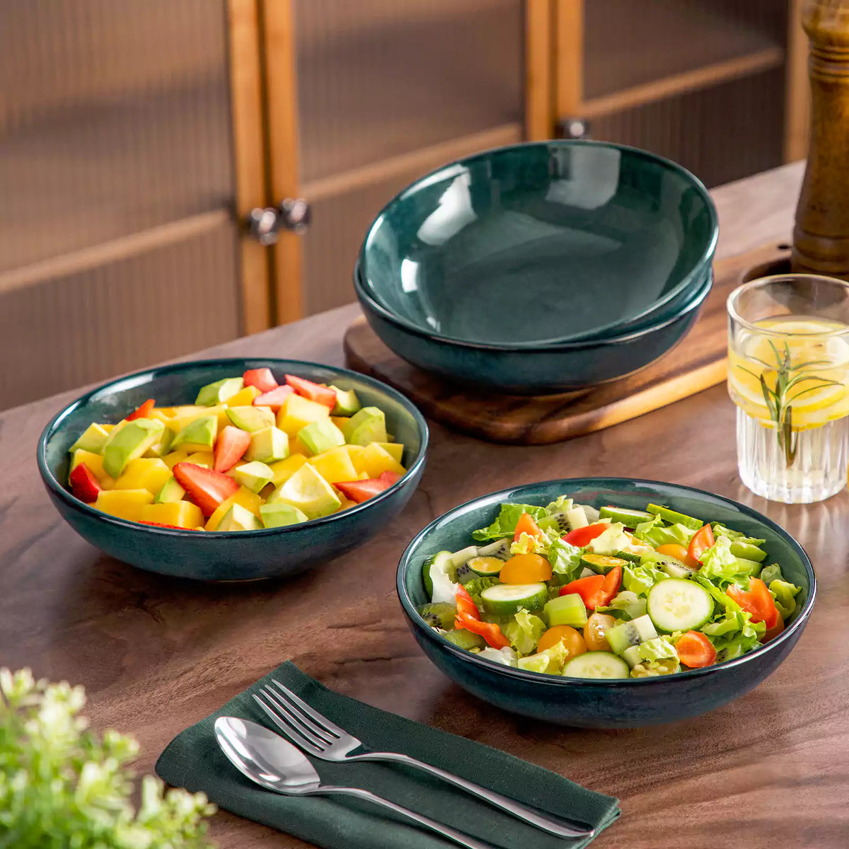Green Stern pasta bowl brimming with fresh fruit and vegetable salad, set on a rustic wooden table