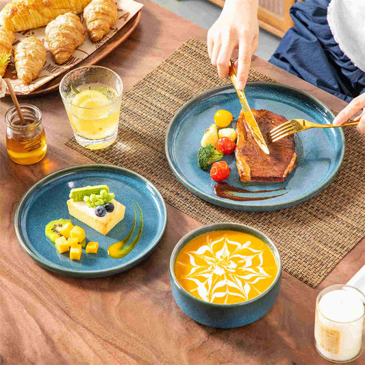 Single place setting of Vega stoneware featuring grilled steak, pumpkin soup, and honey cake, accented with lemonade and a bread basket.