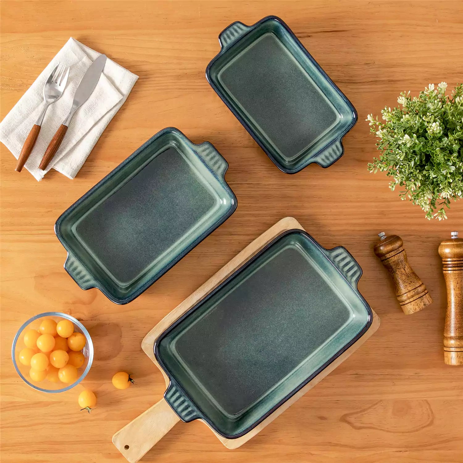 Starry 3 piece stoneware bakeware set with reactive glaze in green on a wooden table