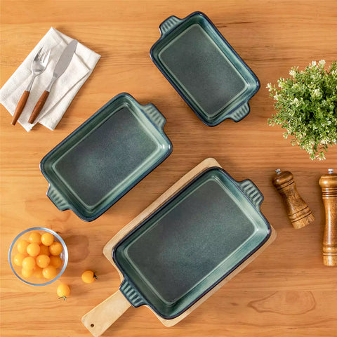 Starry 3 piece stoneware bakeware set with reactive glaze in green on a wooden table