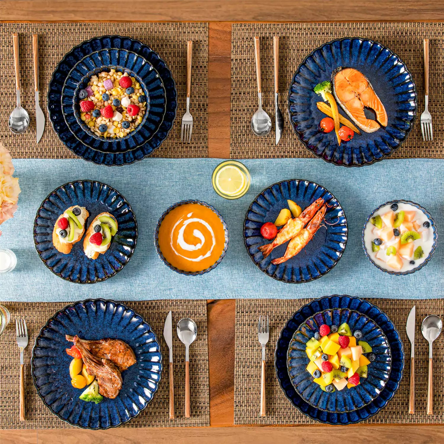 Adonis 18 piece reactive glaze dinnerware set in deep blue with ribbed bowls and plates on a dining table