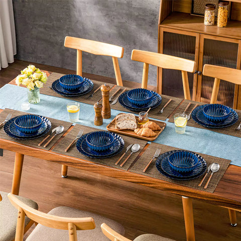 Adonis 18 piece reactive glaze dinnerware set in deep blue with ribbed bowls and plates on a dining table