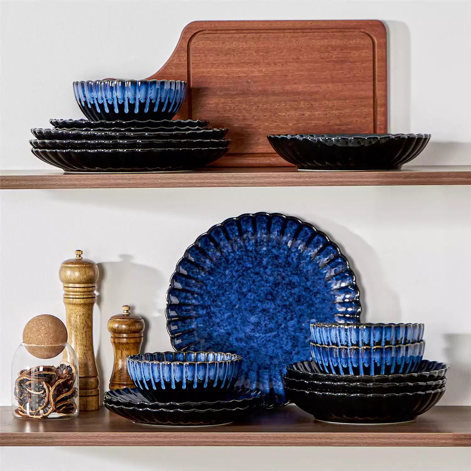 Adonis 16 piece reactive glaze dinnerware set in teal blue with pasta steak and fruit on a wooden dining table
