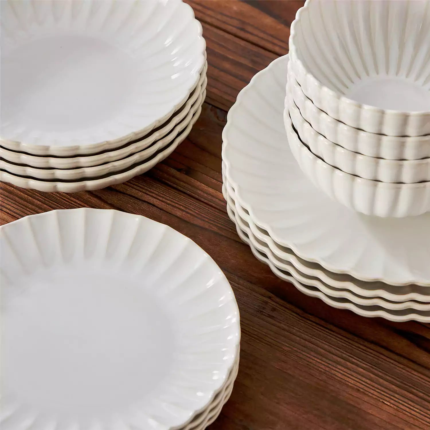 Adonis 16 piece reactive glaze dinnerware set in beige with pasta steak and fruit on a wooden dining table