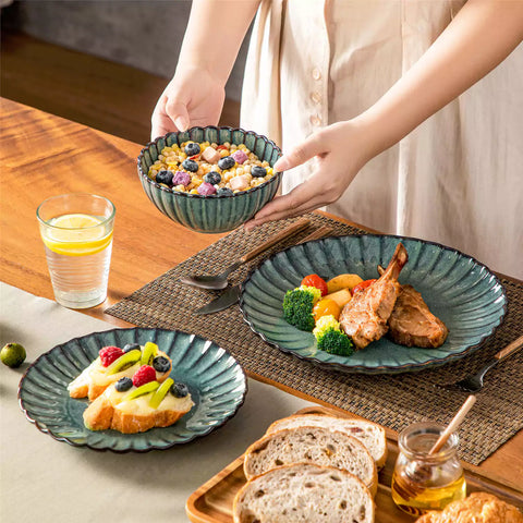 Green reactive glaze stoneware bowls and plates from the Adonis 12 piece set with brown placemats and fresh flowers