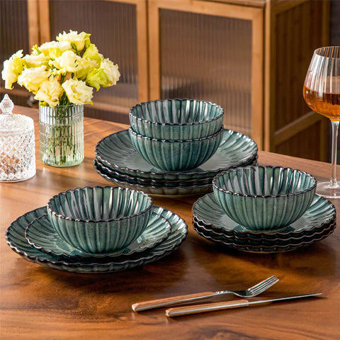 Green reactive glaze stoneware bowls and plates from the Adonis 12 piece set with brown placemats and fresh flowers