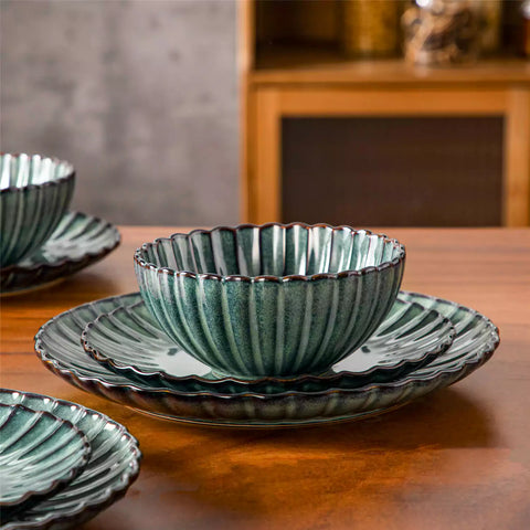 Adonis 18 piece reactive glaze dinnerware set in teal green with ribbed bowls and plates on a dining table