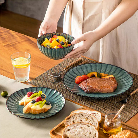 Adonis 18 piece reactive glaze dinnerware set in teal green with ribbed bowls and plates on a dining table