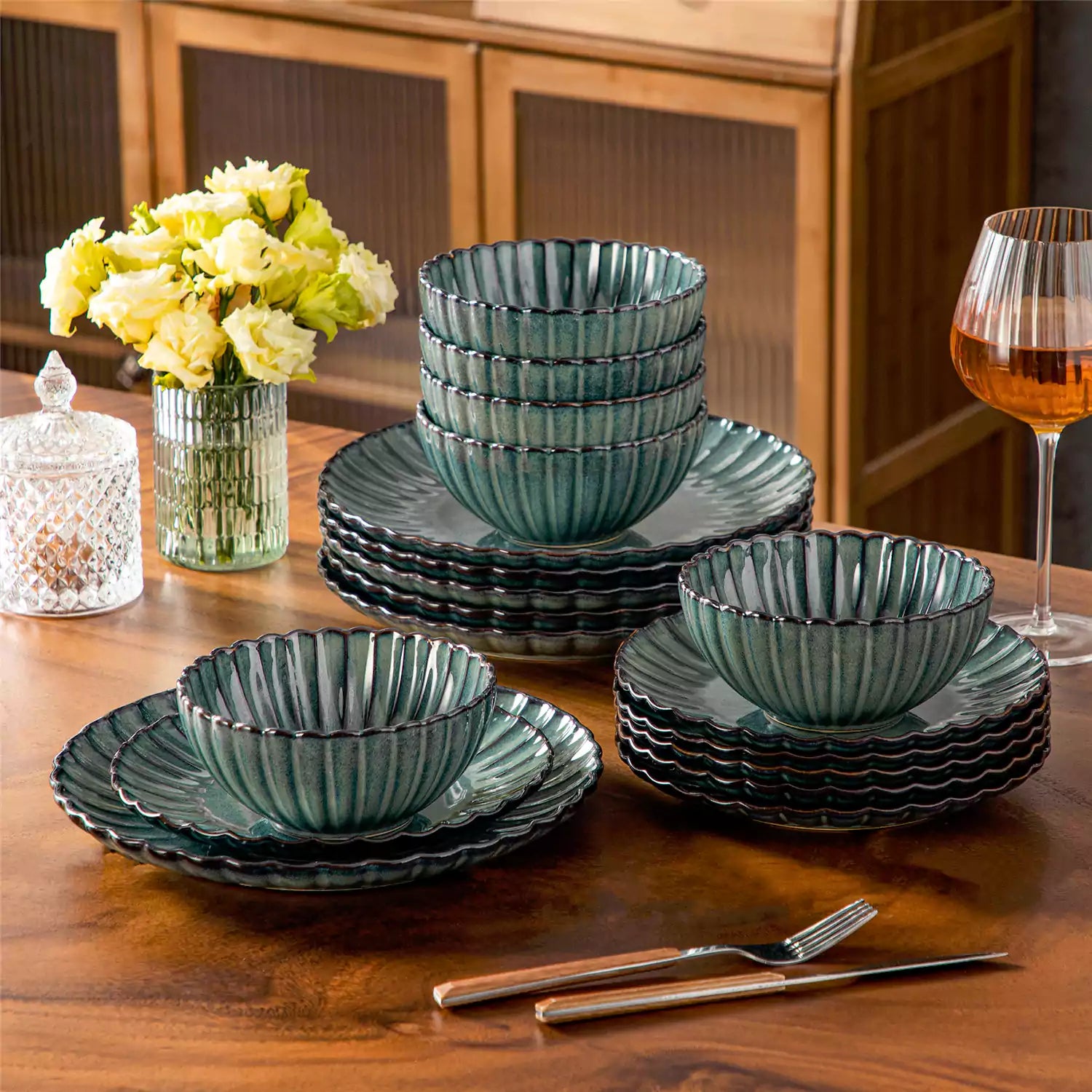 Adonis 18 piece reactive glaze dinnerware set in teal green with ribbed bowls and plates on a dining table