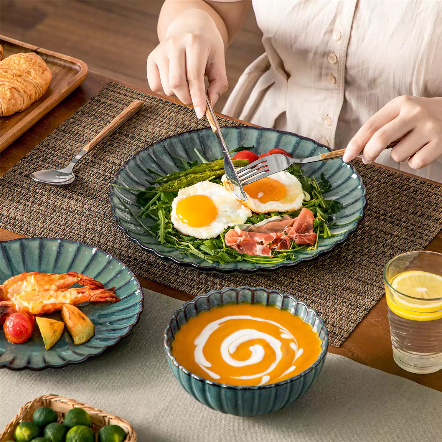 Adonis 18 piece reactive glaze dinnerware set in teal green with ribbed bowls and plates on a dining table