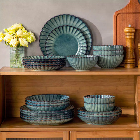 Farmhouse dining table set with Adonis teal green reactive glaze stoneware plates woven placemats and wooden chairs