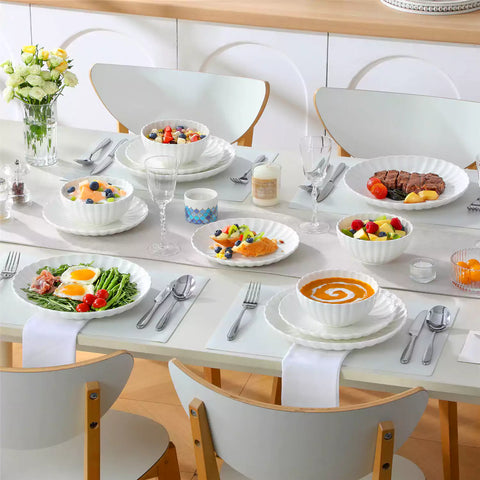 Bright modern dining room with Adonis white porcelain plates bowls white chairs and light wood accents
