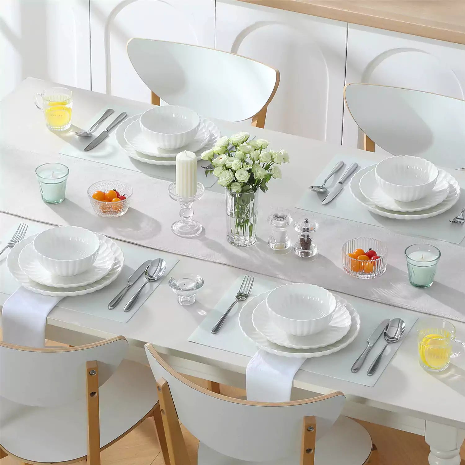 Bright modern dining room with Adonis white porcelain plates bowls white chairs and light wood accents