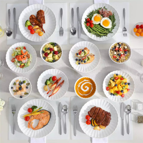 Adonis 18 piece white porcelain dinnerware set styled with food and glassware on a modern dining table