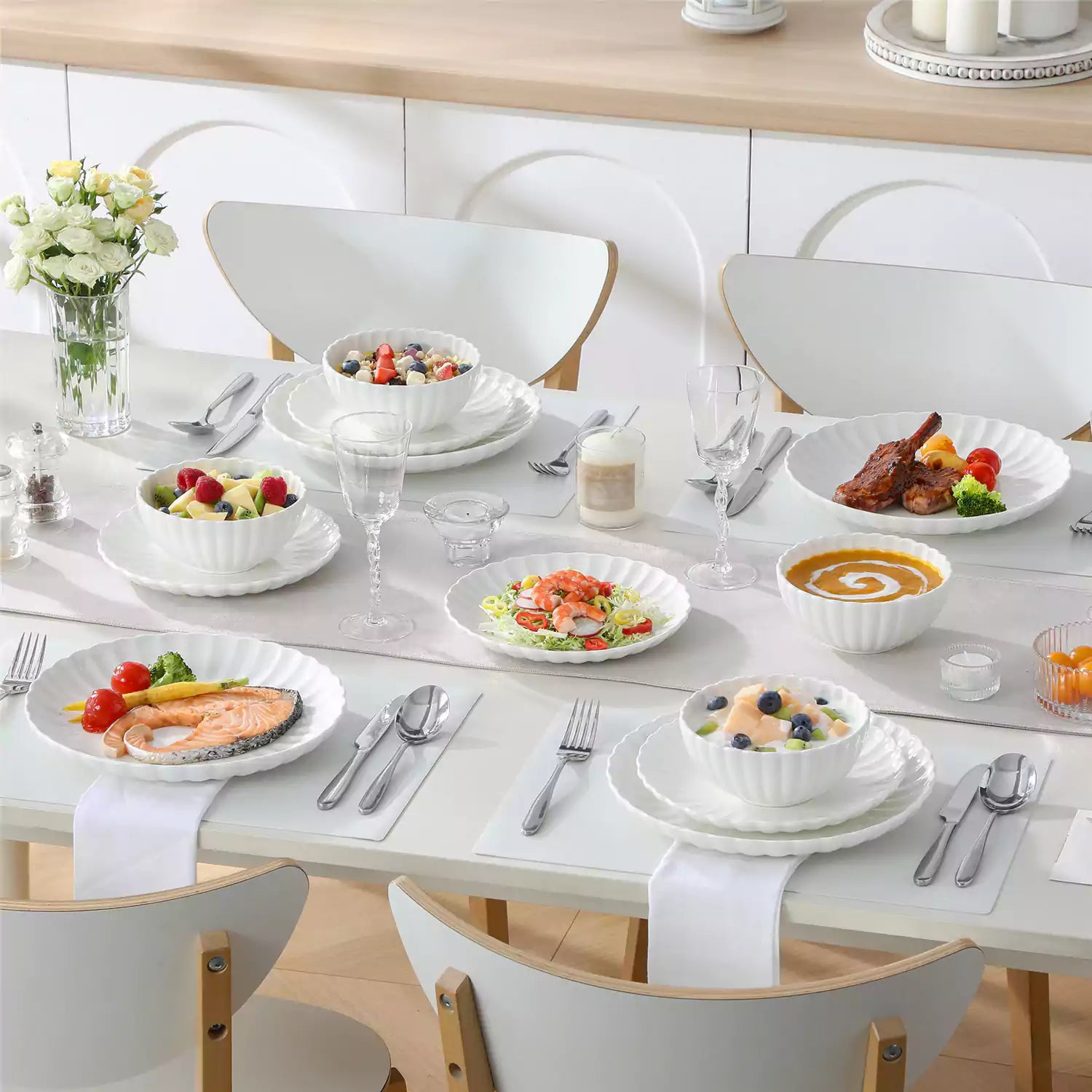 Adonis 18 piece white porcelain dinnerware set styled with food and glassware on a modern dining table