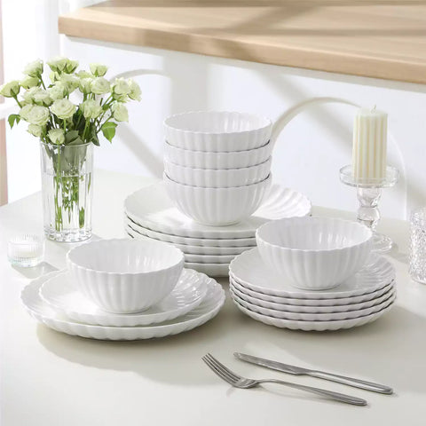 Adonis 18 piece white porcelain dinnerware set styled with food and glassware on a modern dining table