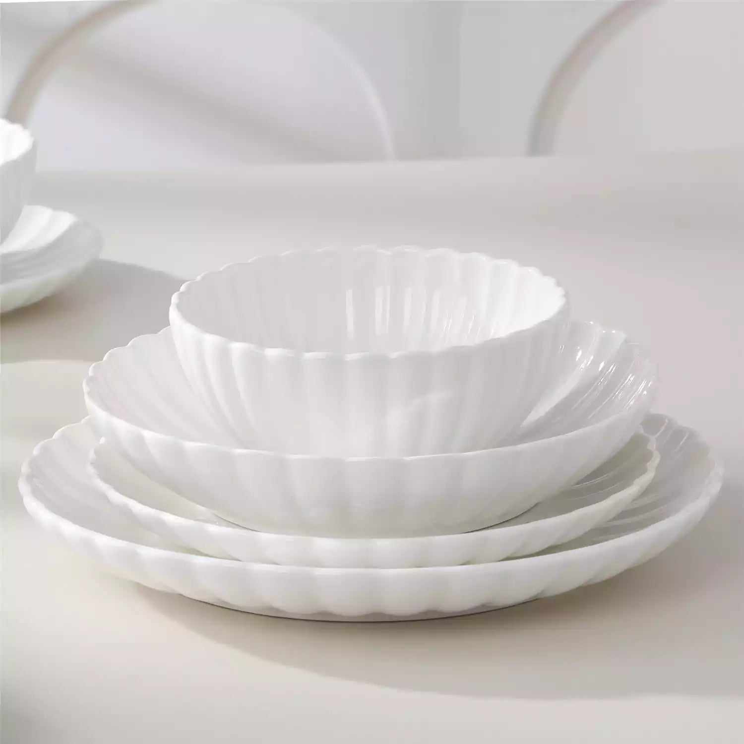 Adonis 24 piece white porcelain dinnerware set for 6 styled with pasta soup and fruit on a modern dining table