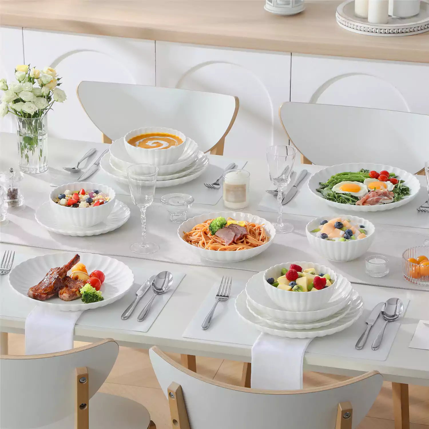 Adonis 24 piece white porcelain dinnerware set for 6 styled with pasta soup and fruit on a modern dining table