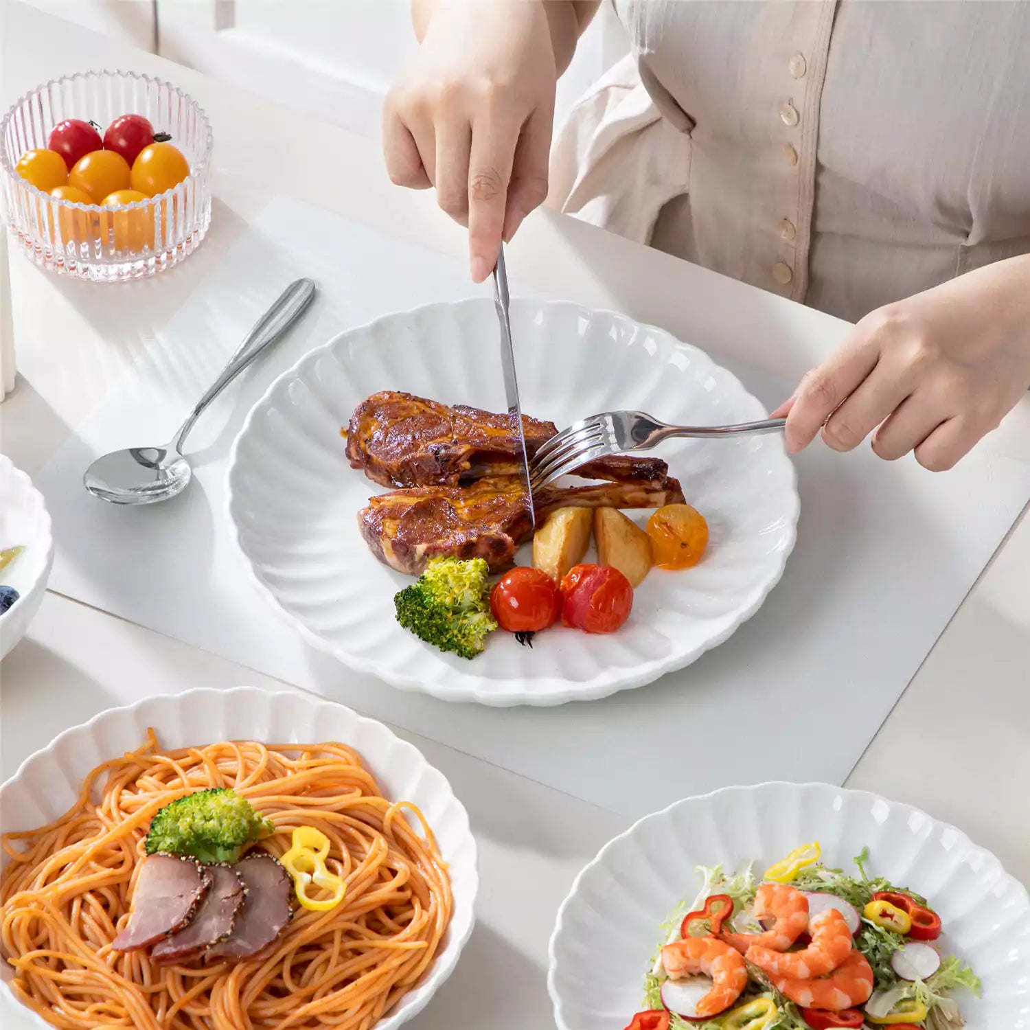 Adonis 24 piece white porcelain dinnerware set for 6 styled with pasta soup and fruit on a modern dining table