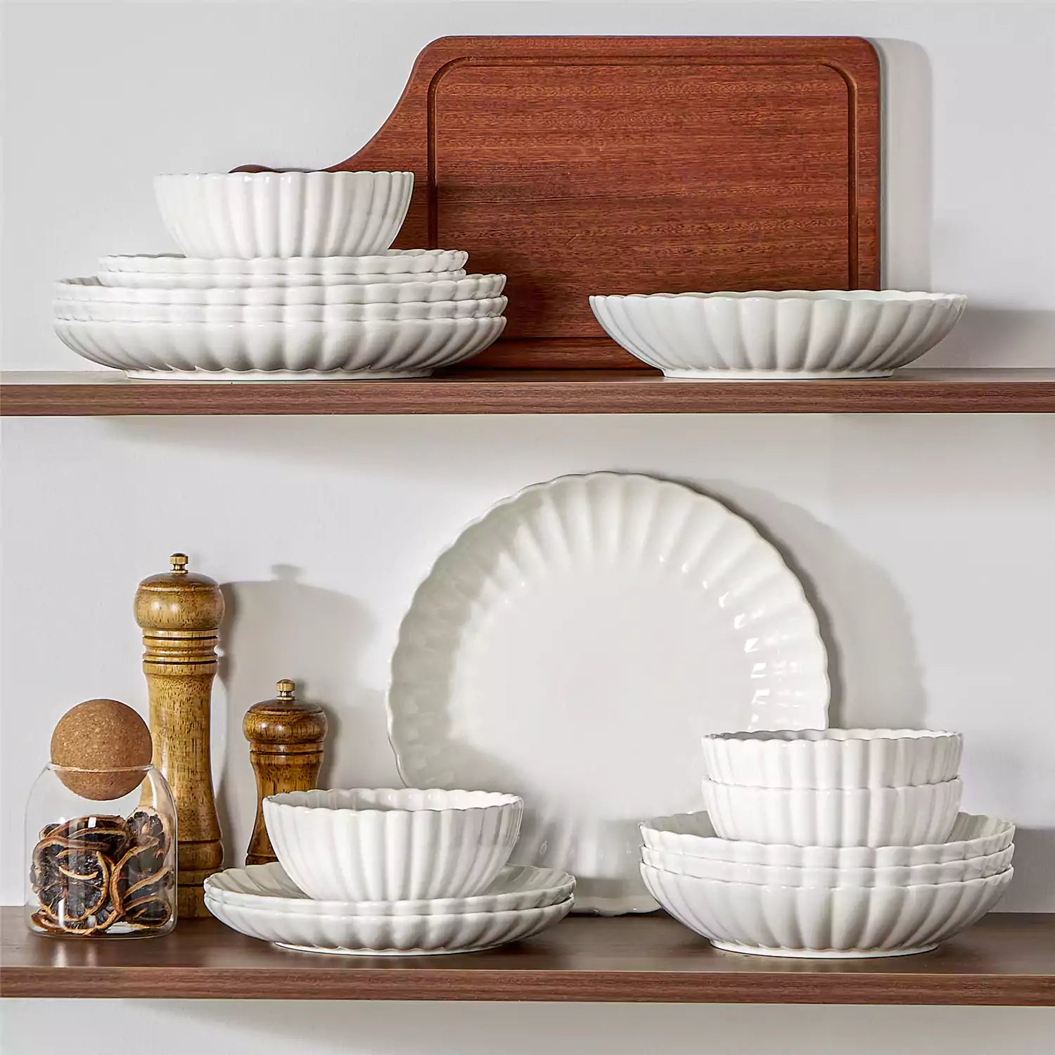 Adonis 16 piece white porcelain dinnerware set with steak pasta and fruit on a wooden dining table