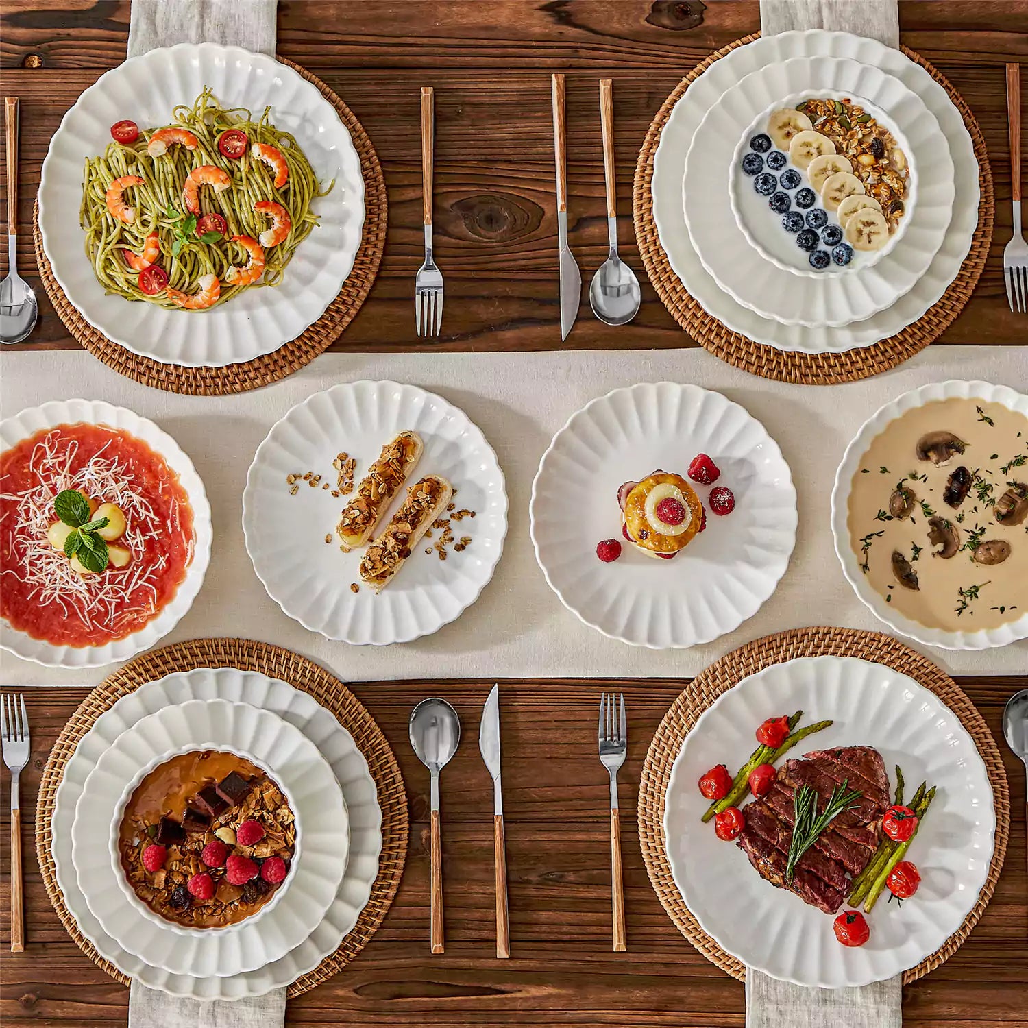 Adonis 16 piece white porcelain dinnerware set with steak pasta and fruit on a wooden dining table