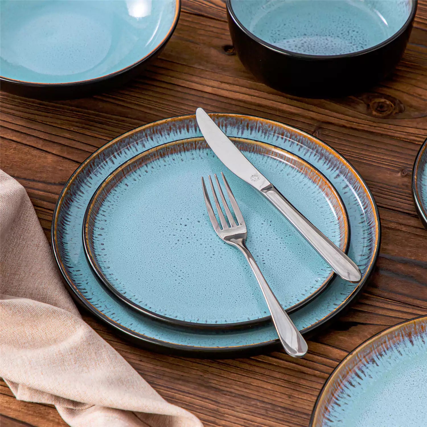 Assorted dishes with soup - dessert - and fruit salad on rustic wooden table - Amber 16-Piece blue stoneware dinnerware set with plates and bowls by vancasso