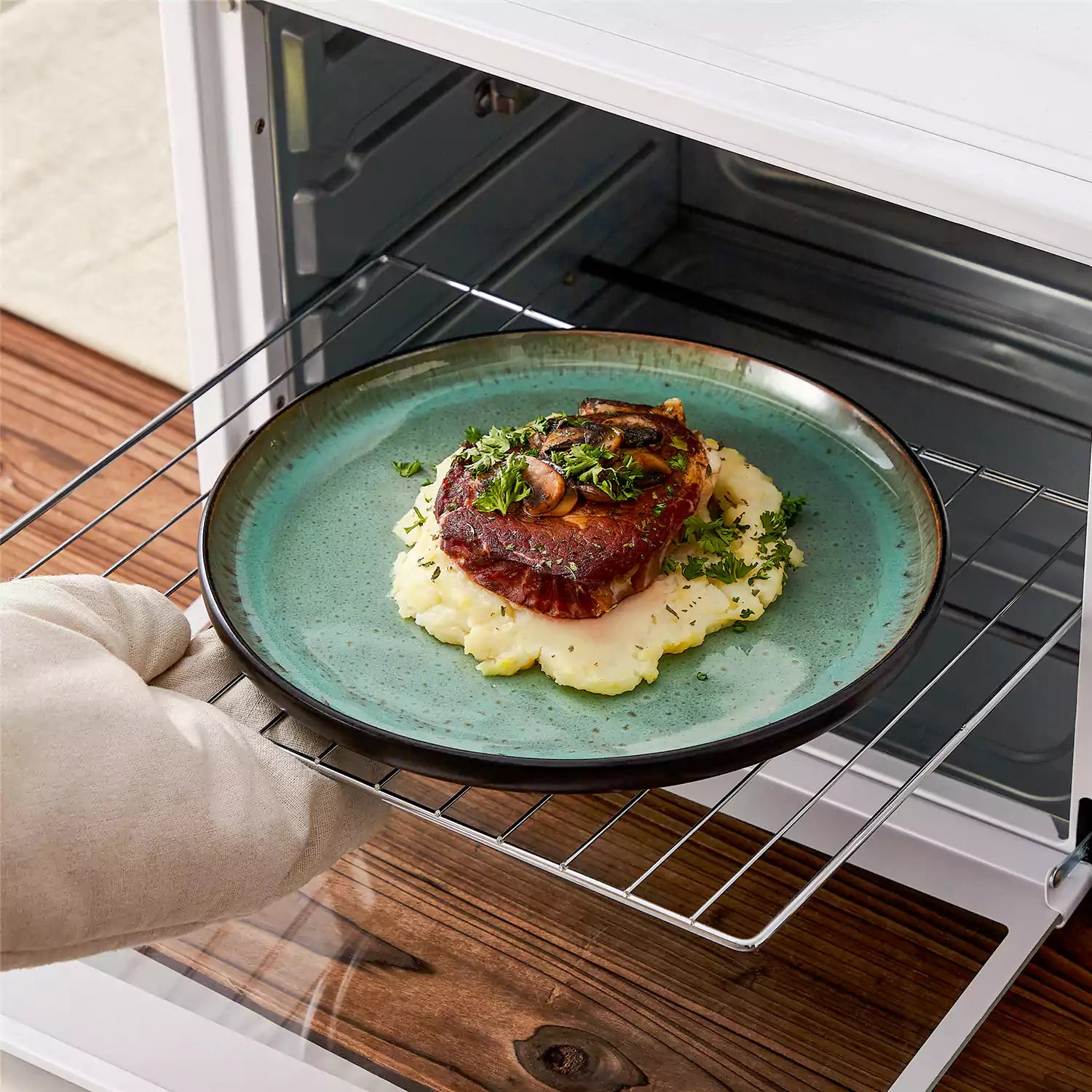Rustic dining table with Amber 12-piece stoneware dinnerware in farmhouse green - featuring reactive glaze plates - bowls - and utensils by vancasso