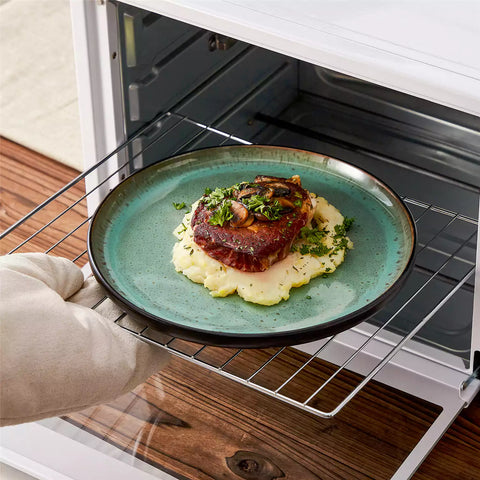 Rustic dining table with Amber 12-piece stoneware dinnerware in farmhouse green - featuring reactive glaze plates - bowls - and utensils by vancasso