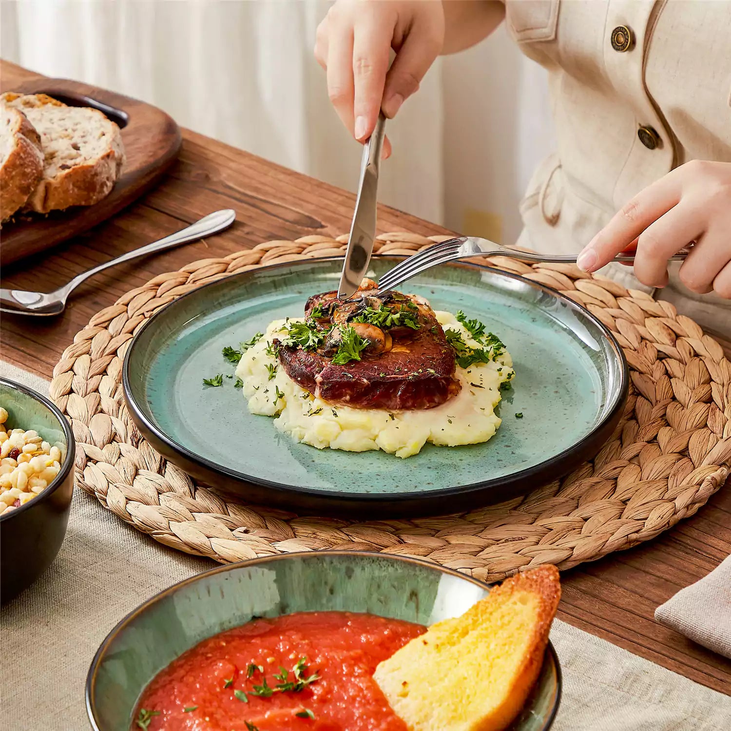 Assorted dishes with soup - dessert - and fruit salad on rustic wooden table - Amber 16-Piece green stoneware dinnerware set with plates and bowls by vancasso